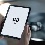 Hands holding a tablet displaying ai logo