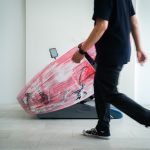 A man walking with a surfboard in his hand