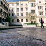person in black jacket walking on sidewalk during daytime