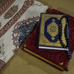 red and blue book on white and blue floral textile