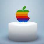 a rainbow apple sitting on top of a white cake