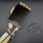 A hand holding a cell phone next to a brain