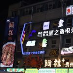 Bright neon signs illuminate a building at night.