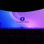 A large screen displays "chatgpt atlas" in a dark room.