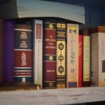A shelf filled with various old books.
