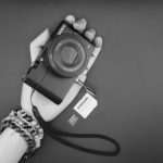 A black and white photo of a person holding a camera