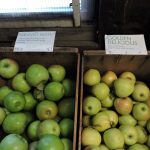 a couple of boxes filled with lots of green apples