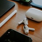 white apple earpods beside black iphone 5