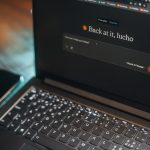 Laptop screen says "back at it, lucho".