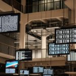 a bunch of television screens hanging from the ceiling