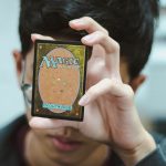 boy holding Magic: The Gathering trading card
