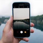 person taking photo of body of water