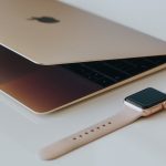 gold case Apple watch beside silver MacBook