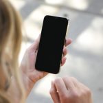 woman holding black iphone 5