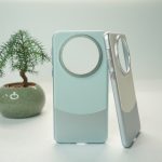 a cell phone with a magnifying glass case next to a potted plant