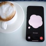 a cup of coffee next to a cell phone