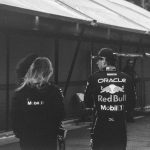 Two people in red bull racing jackets near tent