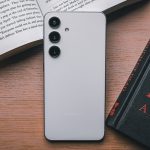 a cell phone sitting on top of a table next to a book