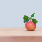red apple on brown wooden table