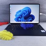 a macbook pro with a feather on the keyboard