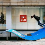 man in black jacket and blue denim jeans jumping on blue and white slide