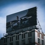 Billboard on top of a building against blue sky