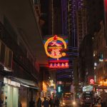 a busy city street at night with neon signs