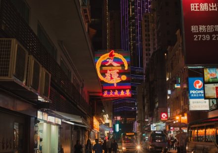 a busy city street at night with neon signs