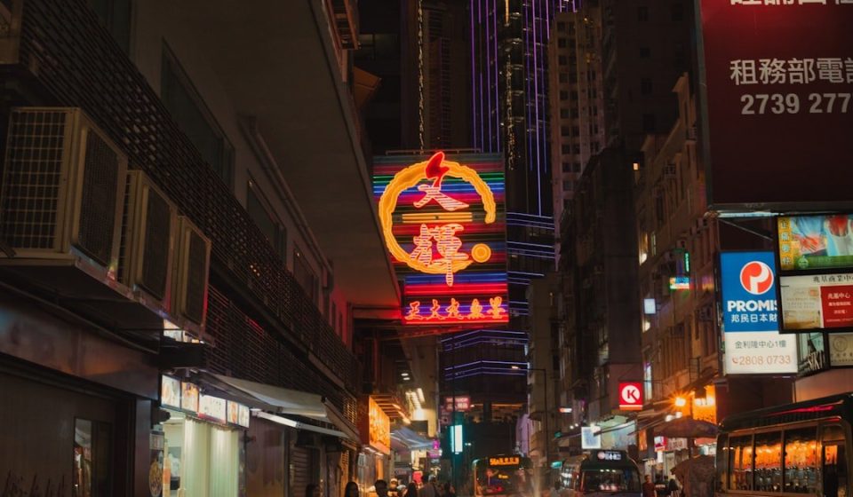 a busy city street at night with neon signs