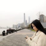 woman wearing fleece jacket using smartphone