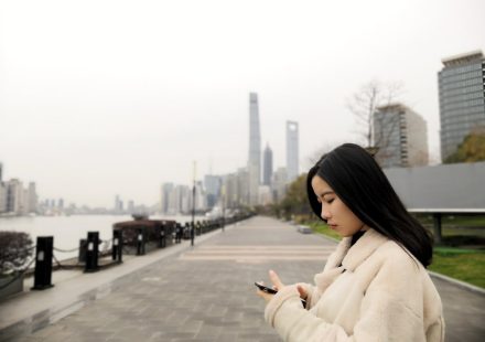 woman wearing fleece jacket using smartphone