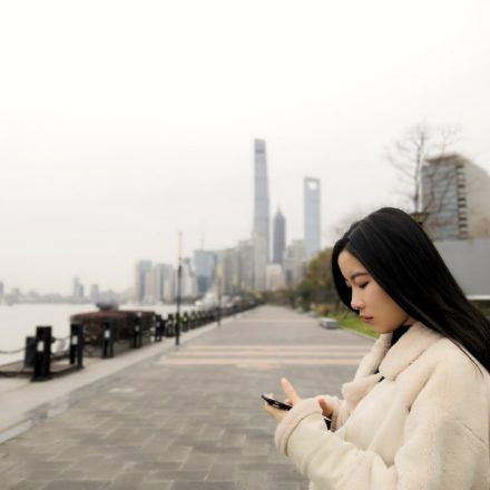 woman wearing fleece jacket using smartphone