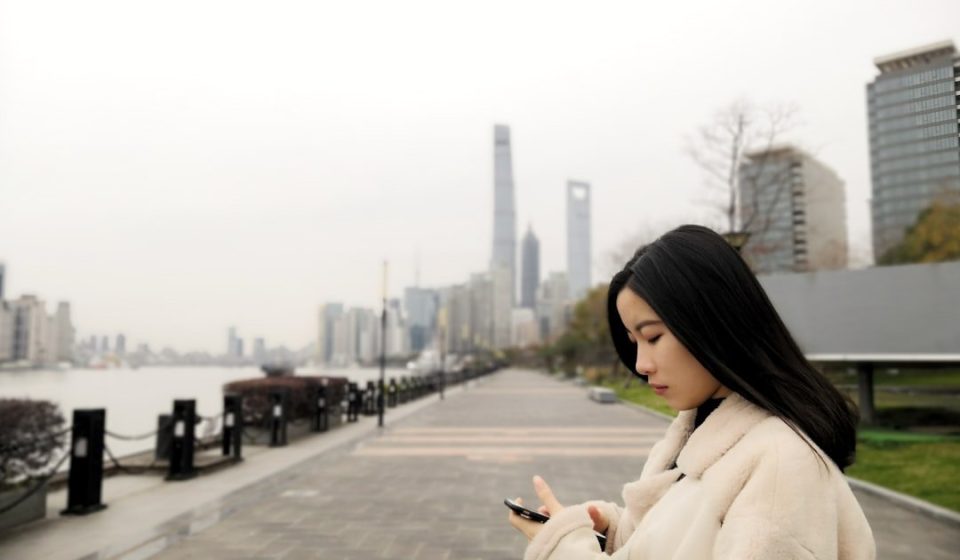 woman wearing fleece jacket using smartphone