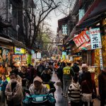 A bustling asian street market is filled with people.