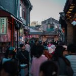Crowd of people walking through an alleyway.