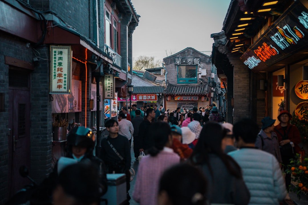 Crowd of people walking through an alleyway.