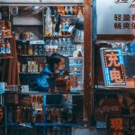 a man standing in front of a store filled with items