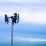 Cell tower against a cloudy blue sky