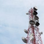 a very tall tower with lots of white dishes on top of it