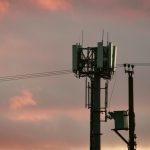 Cell tower against a colorful sunset sky