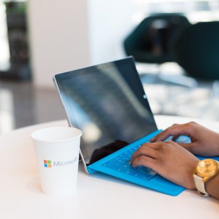 person using blue Microsoft Surface