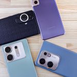 a group of three cell phones sitting on top of a wooden table