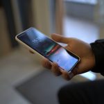 a person holding a smart phone in their hand