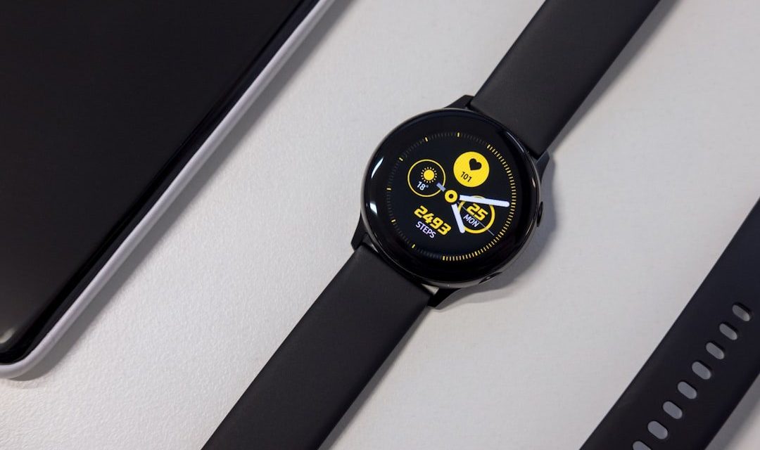 turned-on black smartwatch on white surface