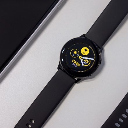 turned-on black smartwatch on white surface