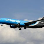 a blue and white airplane flying in the sky