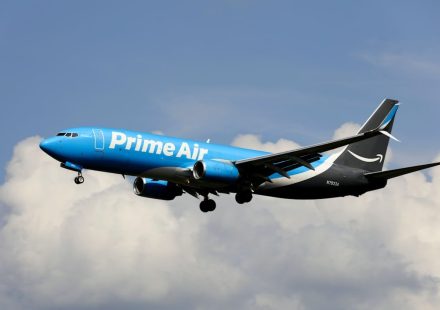a blue and white airplane flying in the sky