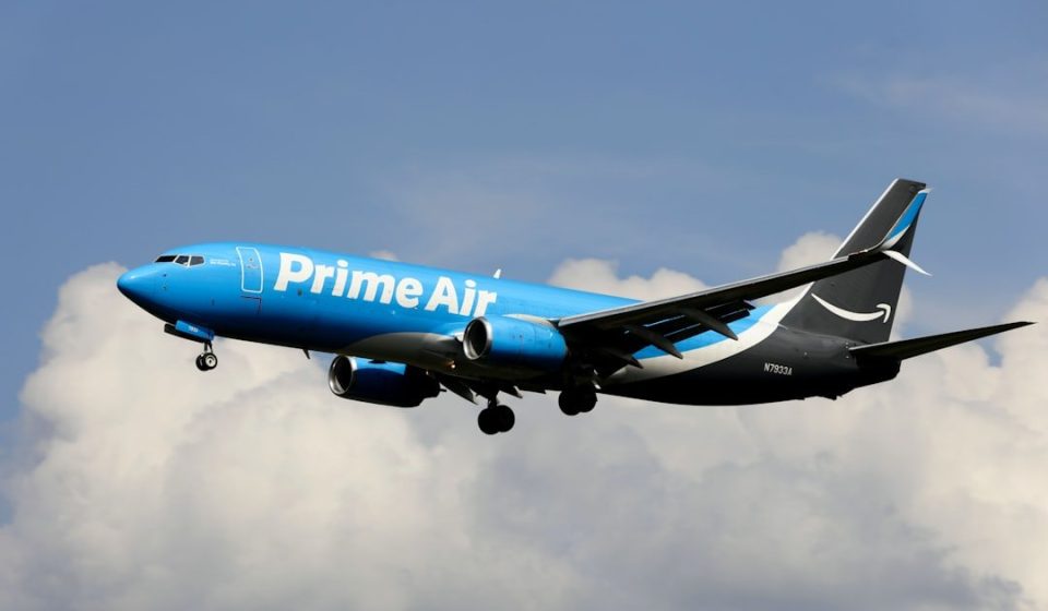 a blue and white airplane flying in the sky