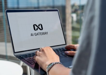Person typing on laptop with ai gateway logo.