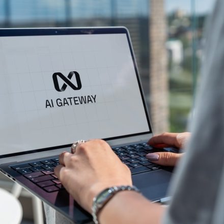 Person typing on laptop with ai gateway logo.